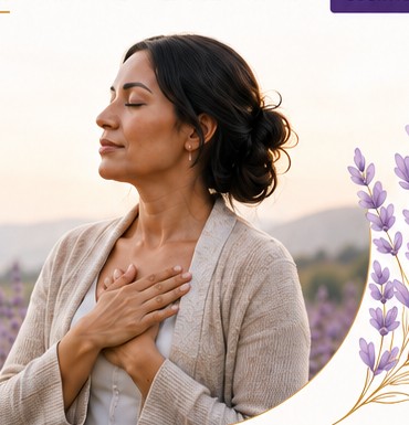 Woman in a lavender field with hand over heart, representing calm, restoration and inner harmony.